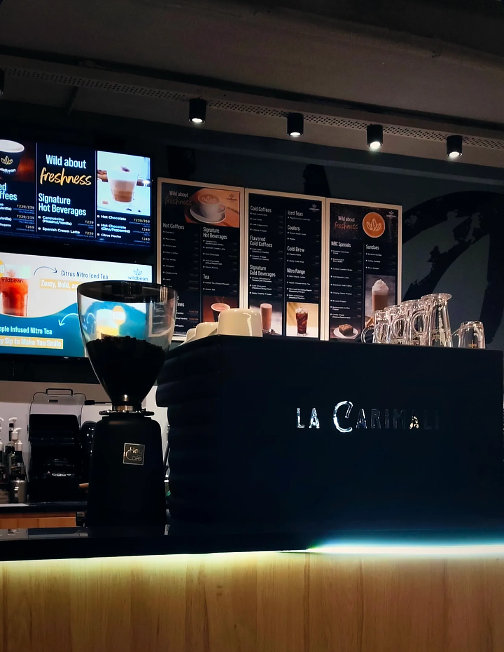 A Wild Bean Café counter with menu boards and an espresso machine