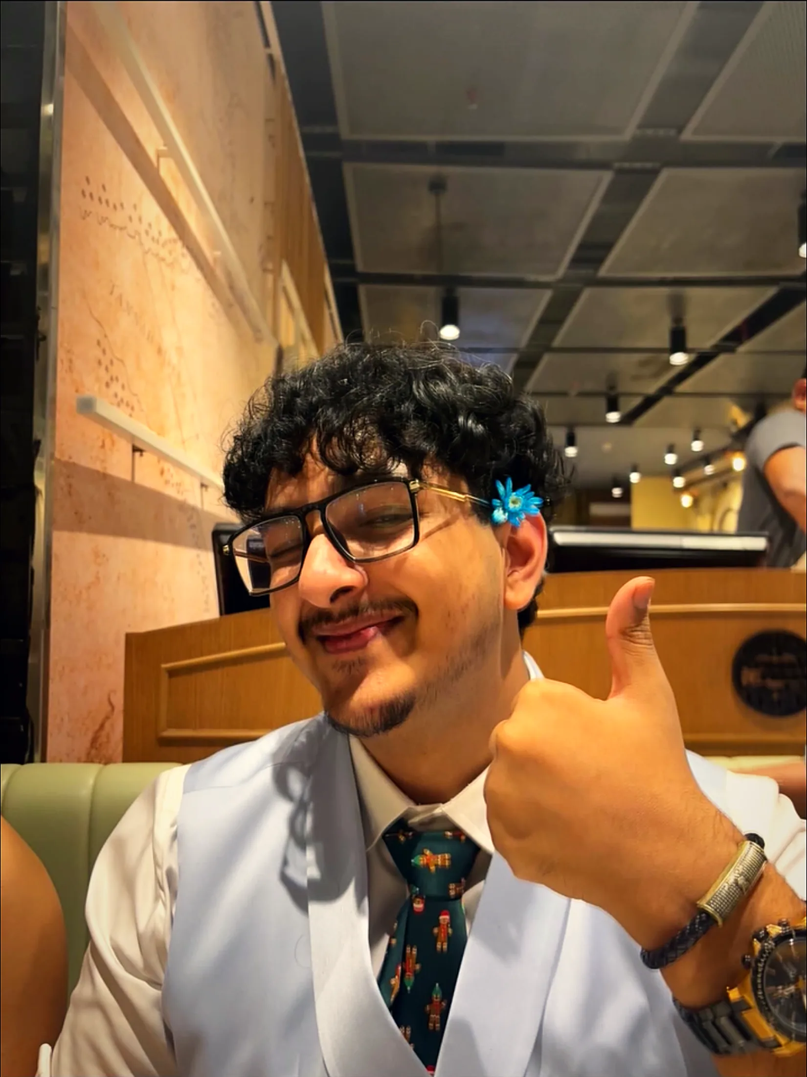Smiling with a thumbs up in a shirt and tie